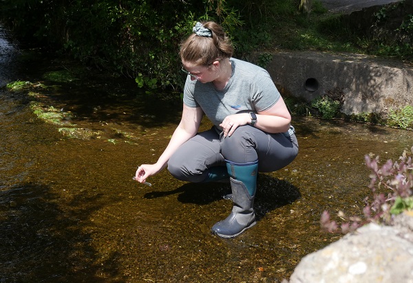 A volunteer testing water for pollution during RiverBlitz 2025